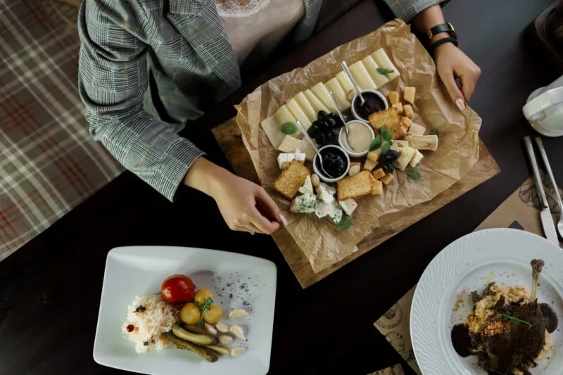 Femeie la masă într-un restaurant unde se aude muzica lentă de fundal