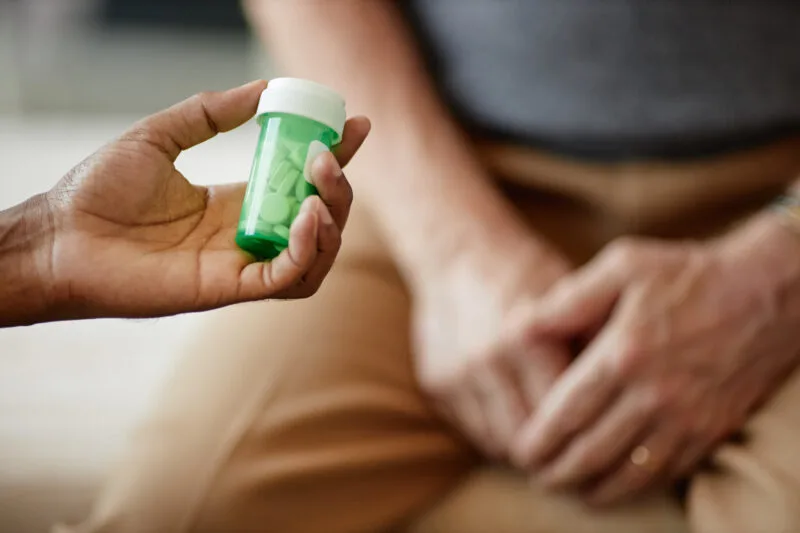 Male hand holding pill bottle 01 08 07 44 21 utc