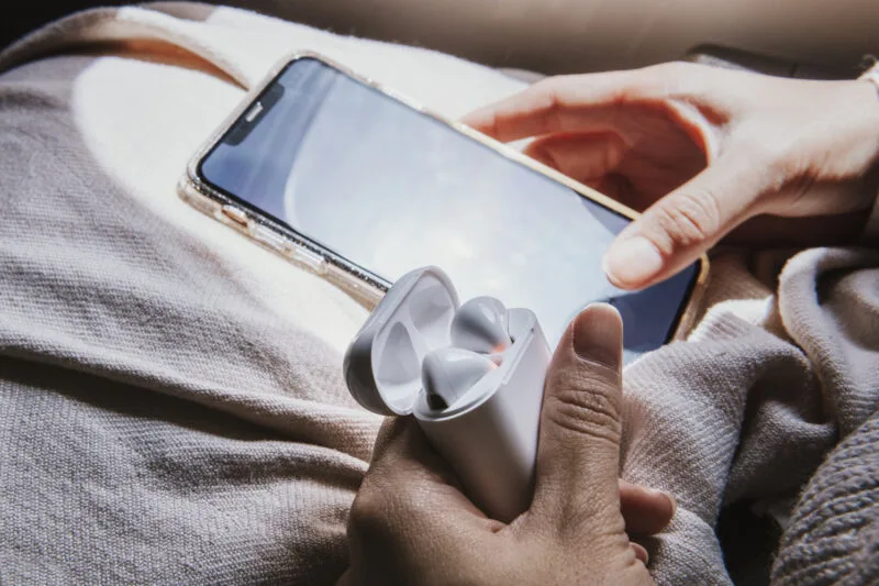 Phone and earbuds on soft beige blanket 03 18 11 58 02 utc