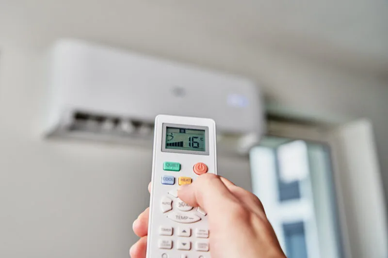 Hand adjusting air conditioner temperature with re 03 24 04 59 42 utc