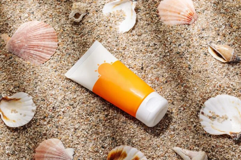Orange tube of sunscreen on sandy beach top view 03 17 04 39 11 utc