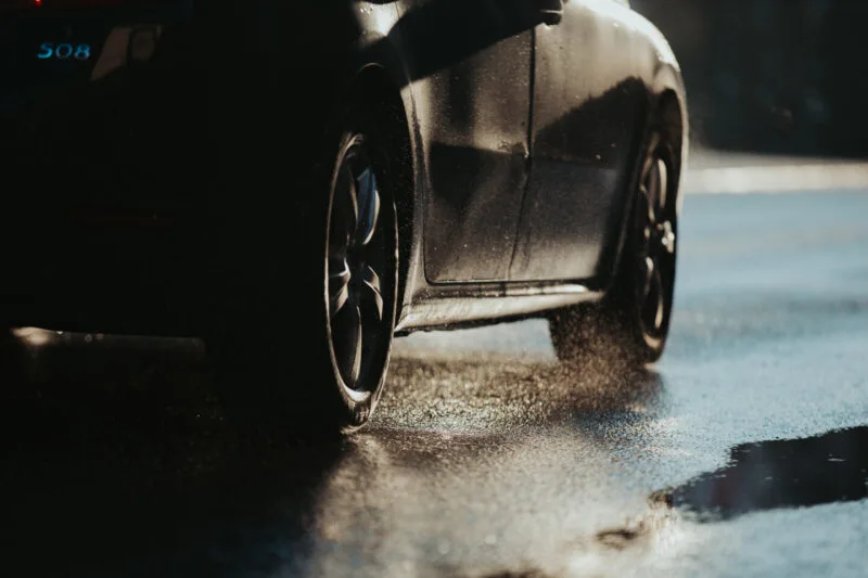Black car driving on a wet road 01 07 07 14 11 utc