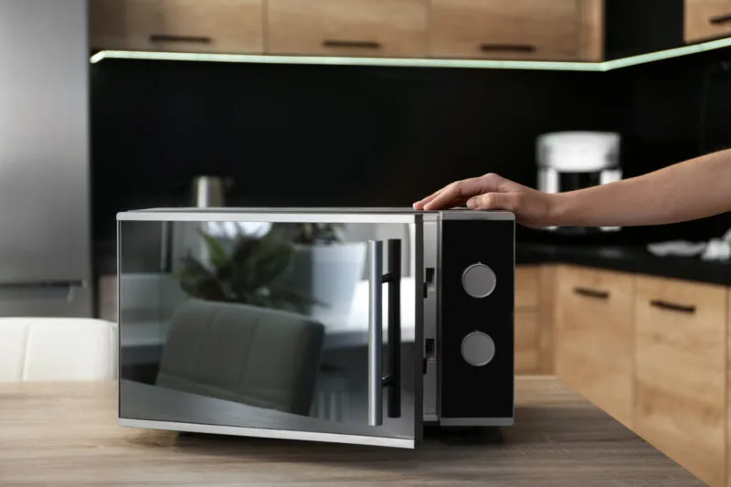 Microwave oven on wooden table in a home kitchen 03 08 23 06 08 utc