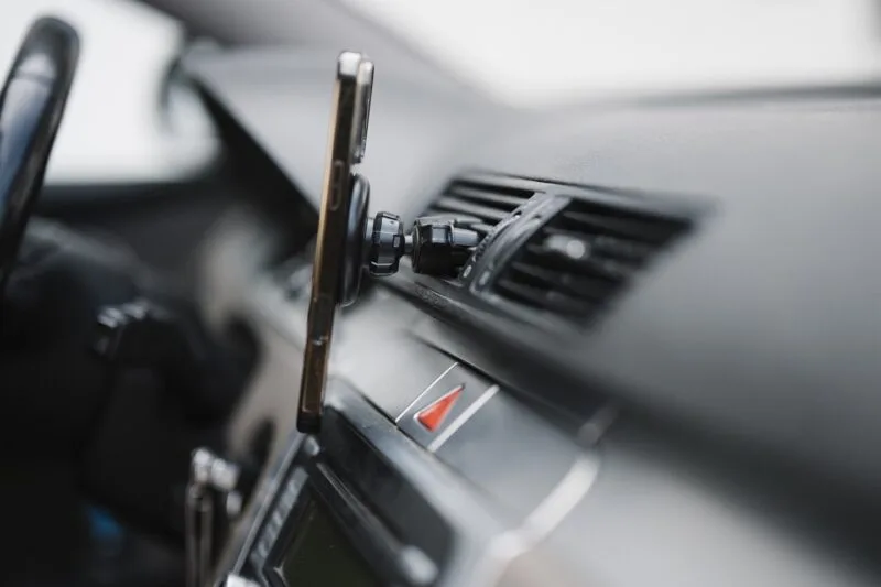 Smartphone montat pe suport pe bordul masinii, folosit pentru navigatie in timpul condusului
