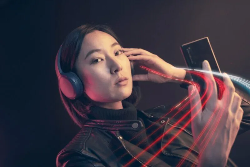 Femeie folosind un smartphone cu căști, pentru streaming audio-video