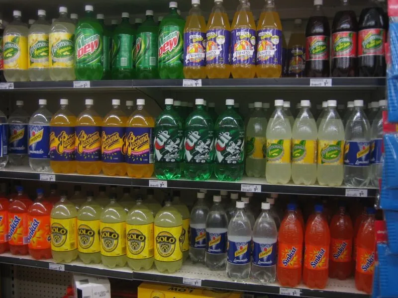 Raft de magazin plin cu baze de plastic si doze de bauturi carbogazoase