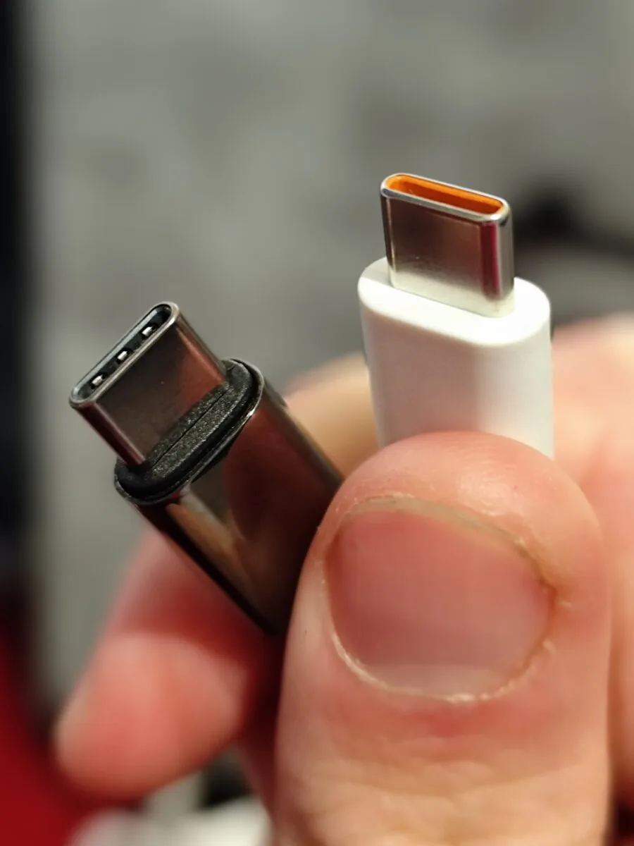 Doi conectori USB-C ținuți în mână