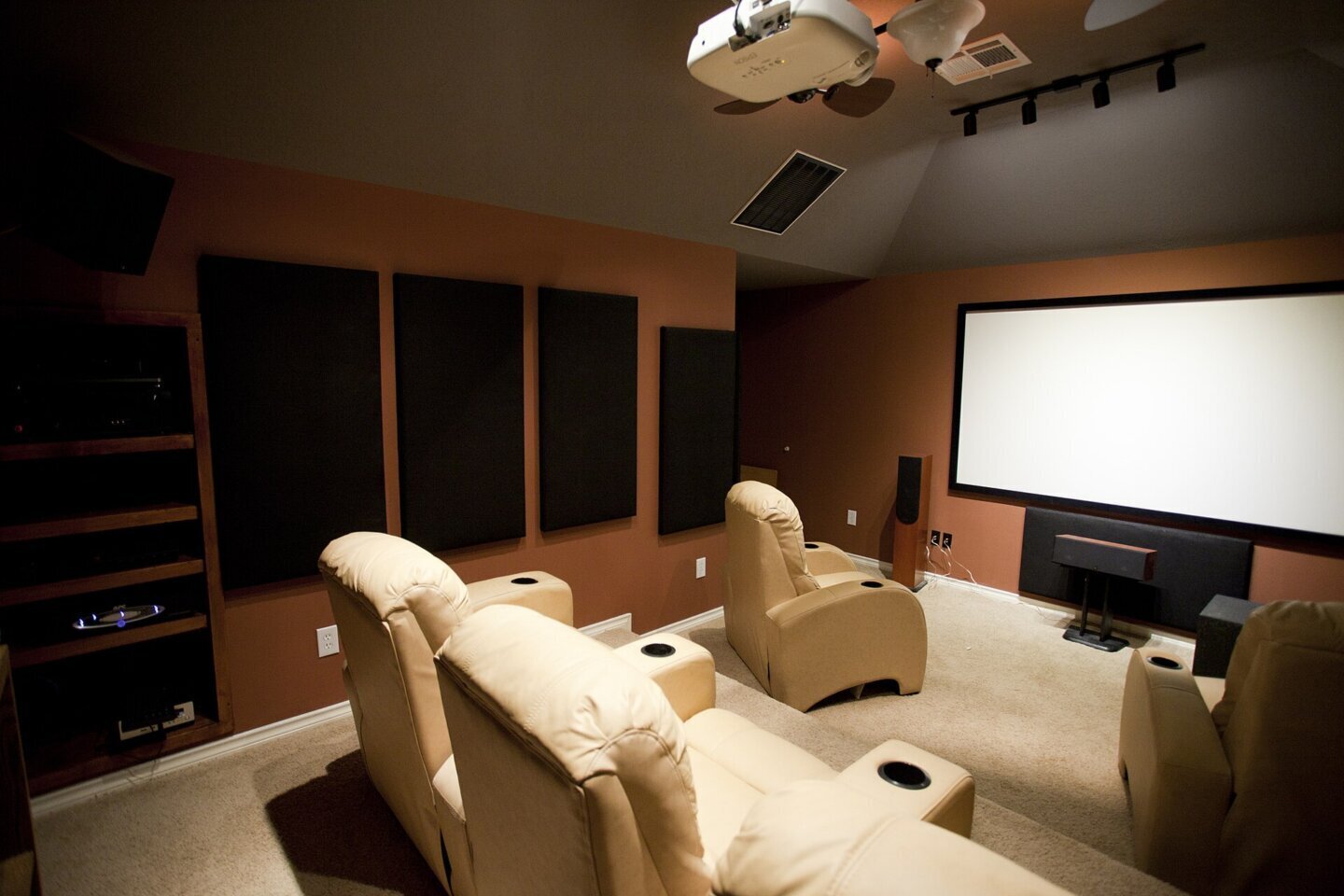 Montarea televizorului pe perete: cameră de home cinema cu ecran mare și scaune orientate spre el