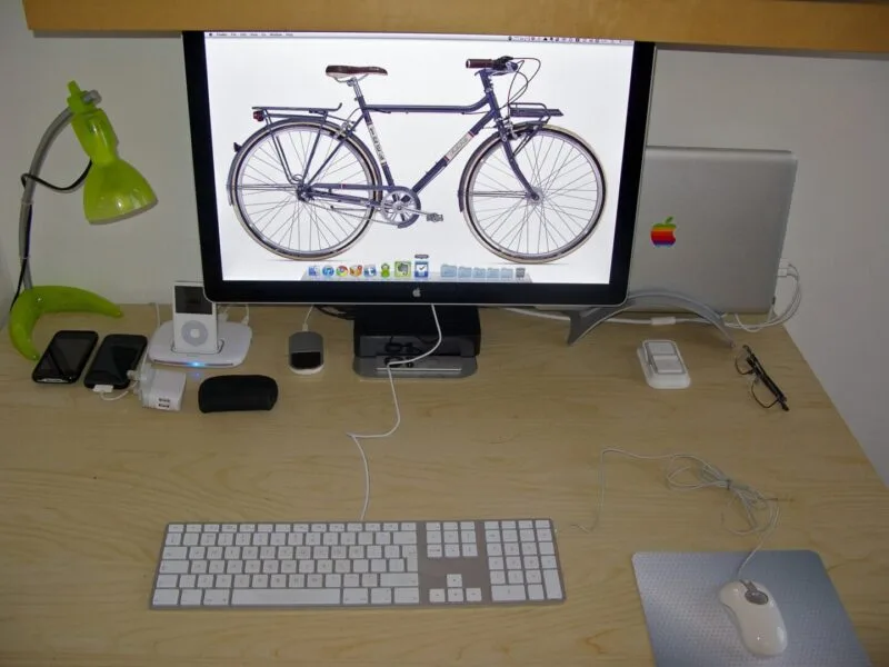 Laptop deschis pe un birou, alături de accesorii de lucru