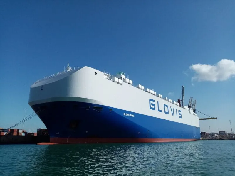 Navă car carrier de tip PCTC acostată la cheu, cu rampa coborâtă pentru încărcarea mașinilor