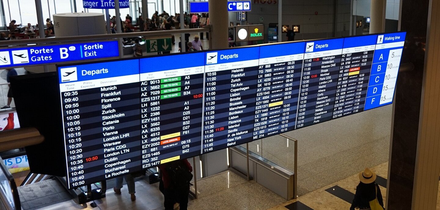 Panou electronic cu zborurile de plecare intr-un terminal de aeroport, alerte de preț în AI Mode
