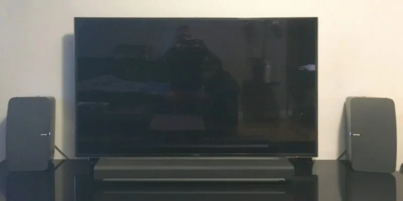 Soundbar Sonos și boxe wireless PLAY:5 amplasate sub un televizor Samsung UE55F9000 într-un living