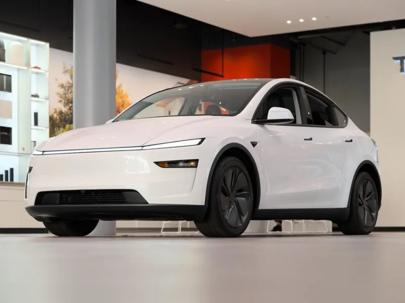 Tesla Model Y alb parcat pe stradă, cu mânerele de ușă retractabile la nivelul caroseriei