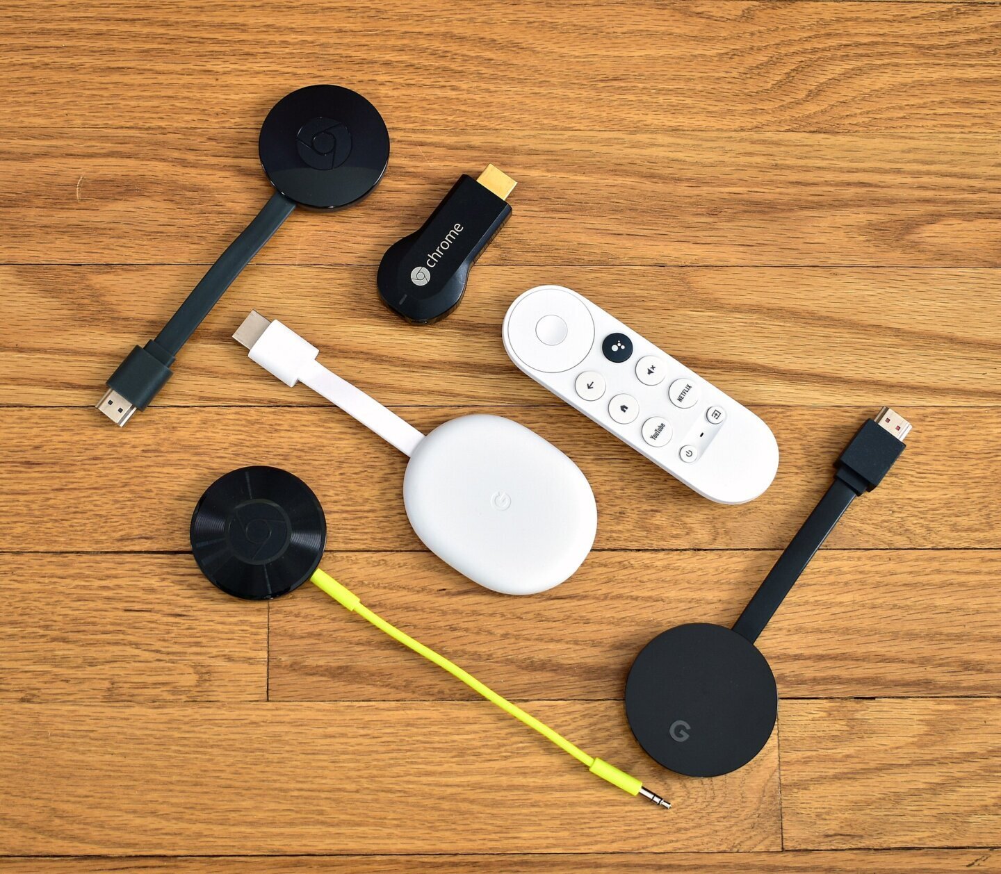 Mai multe generații de stick de streaming Chromecast așezate pe o suprafață deschisă