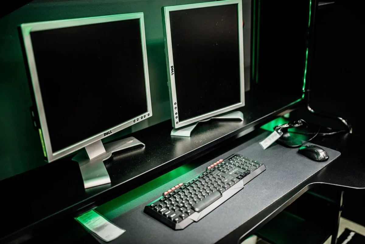 Două monitoare pe birou, cu tastatură și mouse conectate prin USB