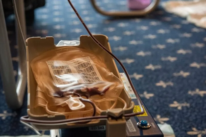 Donator de sânge asistat de personal medical într-un centru de transfuzii