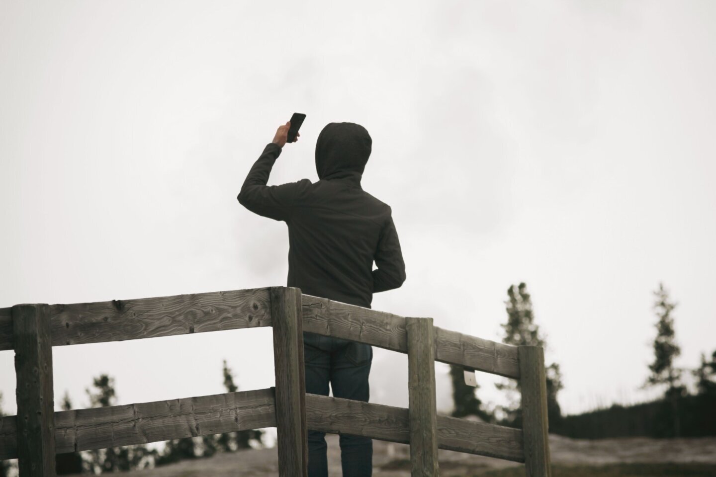 Bărbat care ține telefonul la lungimea brațului și își face un selfie