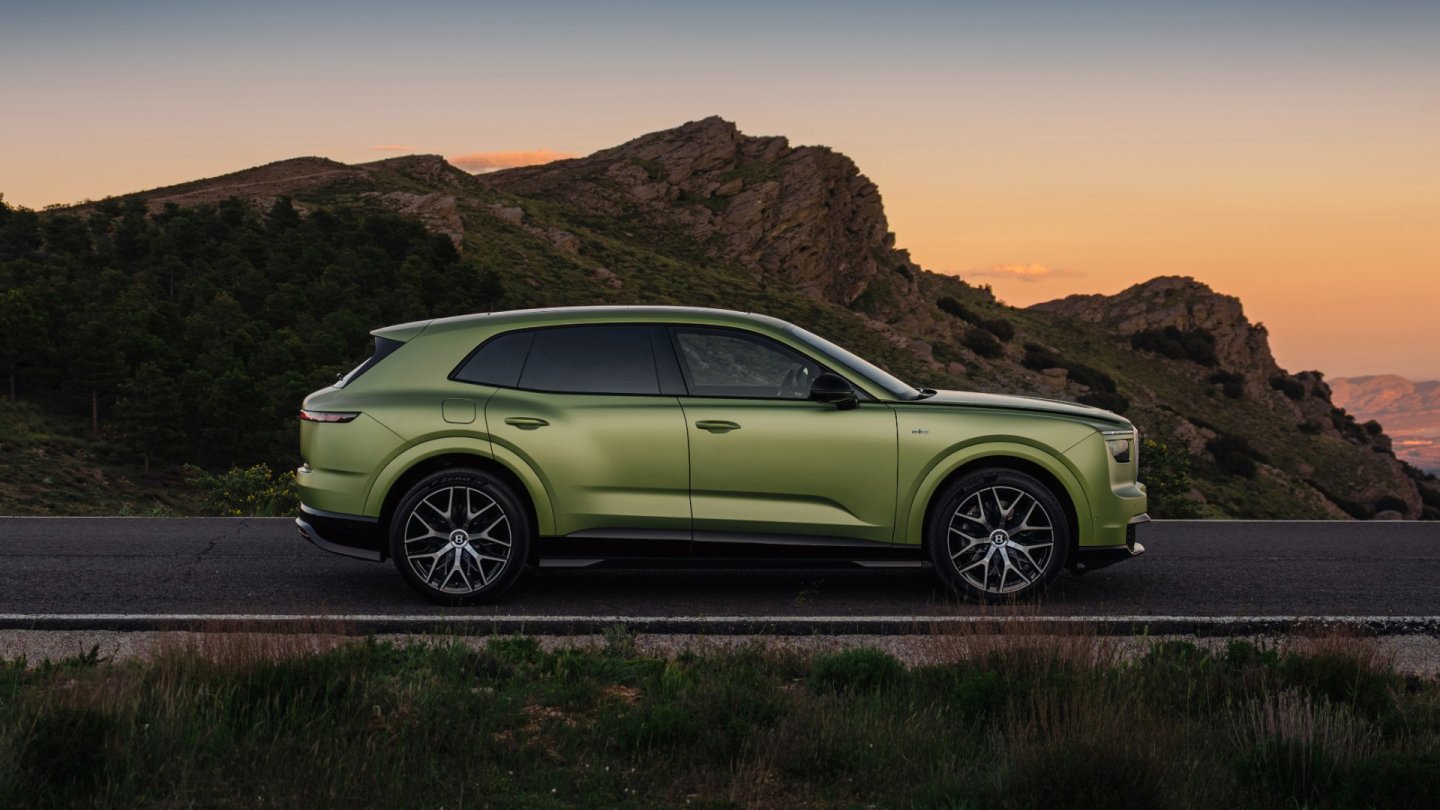 Bentley Torcal verde deschis oprit pe marginea unui drum de munte, văzut din lateral, cu cerul portocaliu al apusului în fundal