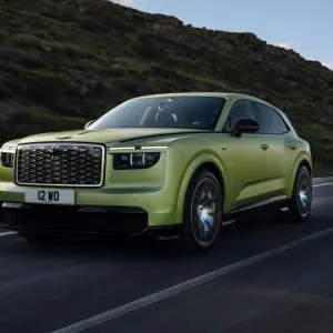 SUV-ul electric Bentley Torcal, vopsit în verde deschis, rulând pe un drum de munte asfaltat, văzut din față