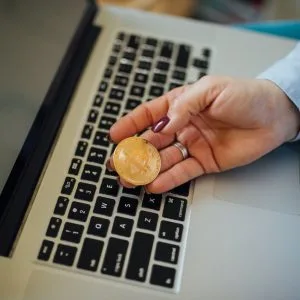 prețul bitcoin Mână care ține o monedă aurie decorativă cu simbolul Bitcoin