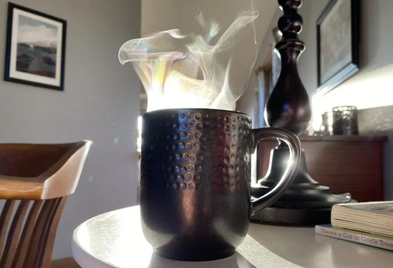 Cană albă cu cafea fierbinte din care se ridică abur