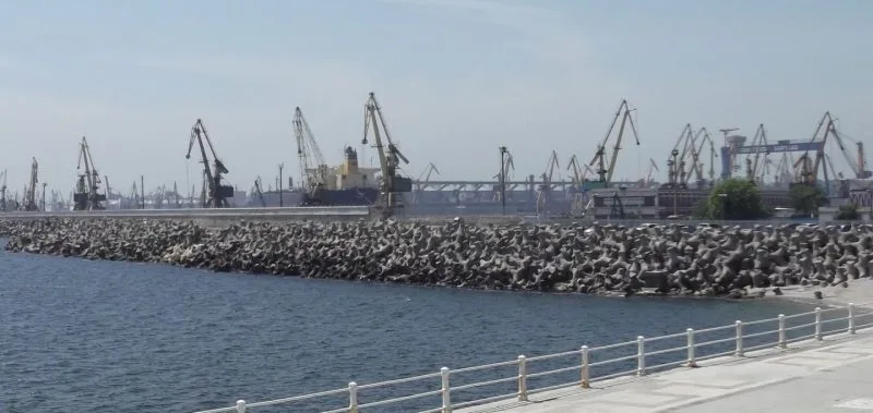 Dig din port acoperit cu blocuri de beton, cu macarale portuare în fundal