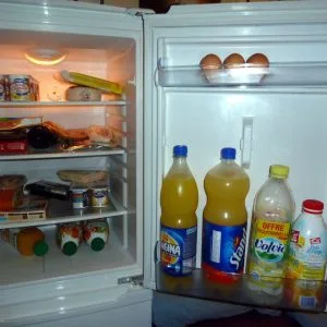 curățarea frigiderului Interiorul unui frigider deschis, cu alimente pe rafturi și în ușă