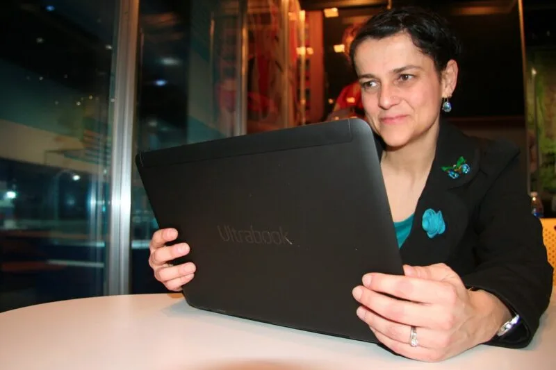 Laptop subțire deschis, folosit pe un birou