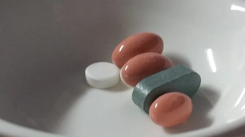 Pastile și capsule de medicamente așezate pe o suprafață albă