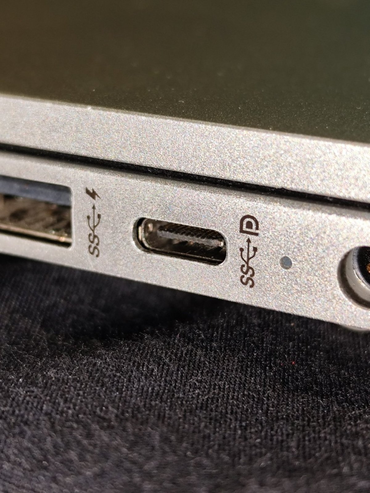 Port USB-C pe marginea unui laptop, lângă alte porturi