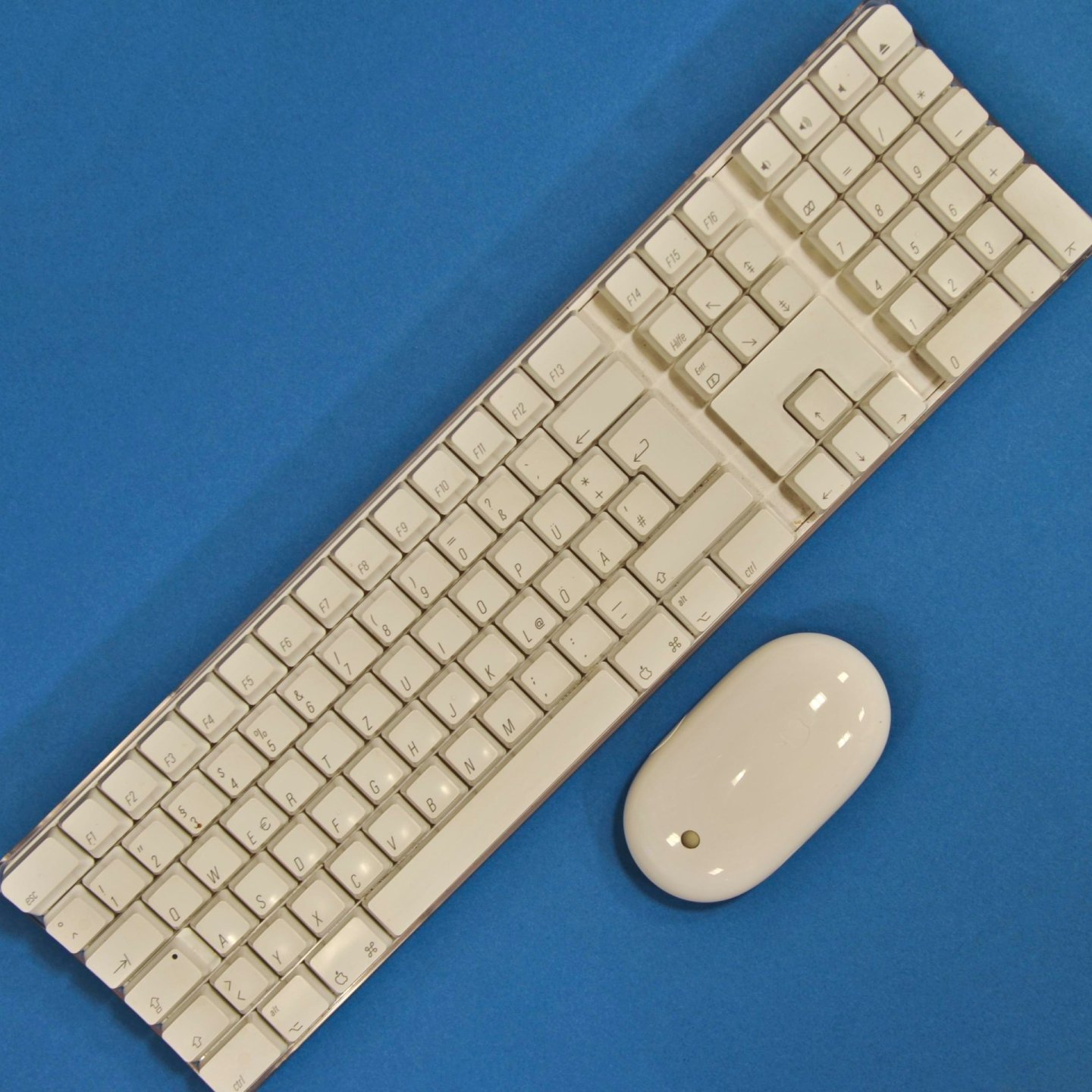 Tastatură și mouse wireless Bluetooth albe, pe fundal albastru