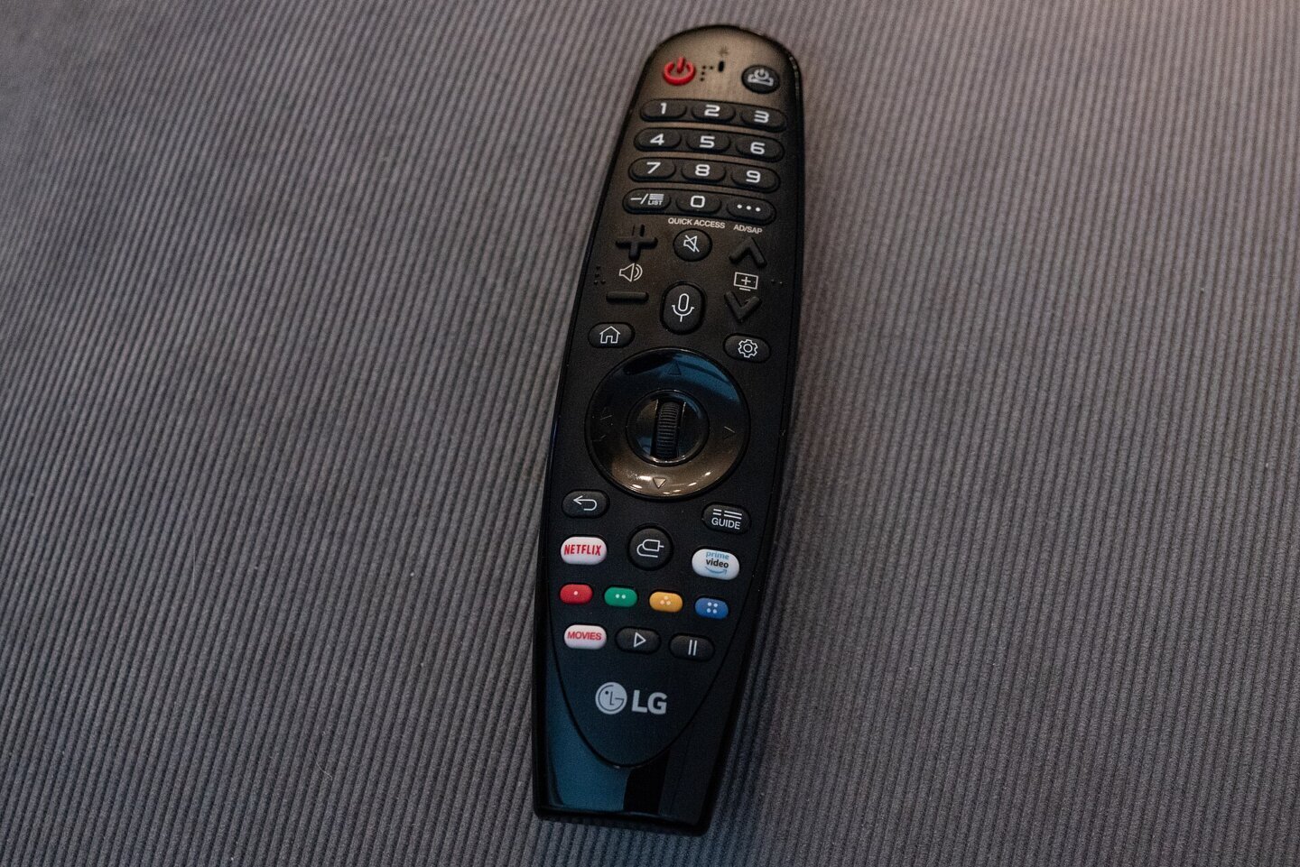 Telecomandă cu buton de voce pentru televizoare LG, ținută în mână