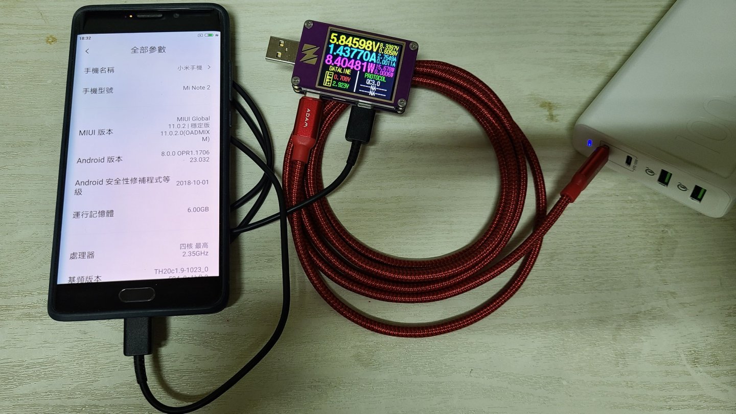 Telefon Xiaomi Mi Note 2 încărcat de la o baterie externă, printr-un tester USB care afișează tensiunea, curentul și puterea
