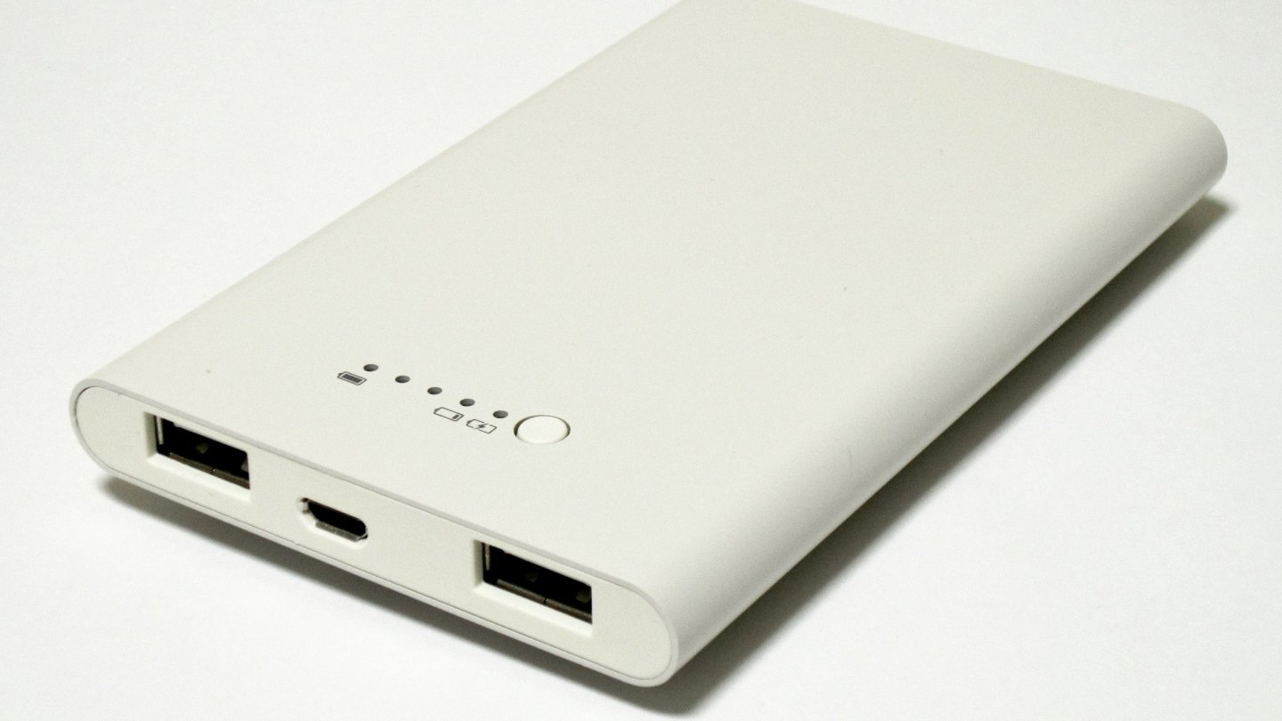 Baterie externă albă, subțire, cu două porturi USB și indicatoare LED, pe fundal alb