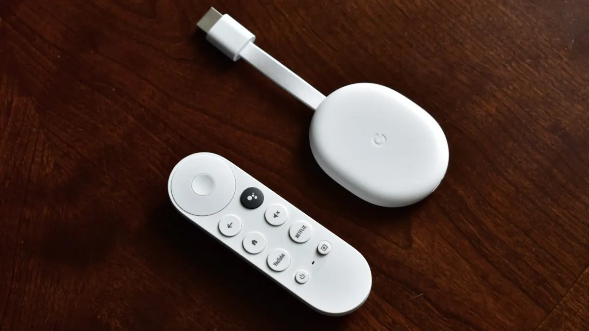 Google TV Streamer Dispozitiv de streaming Chromecast with Google TV alb, cu telecomanda Bluetooth, pe o masă din lemn