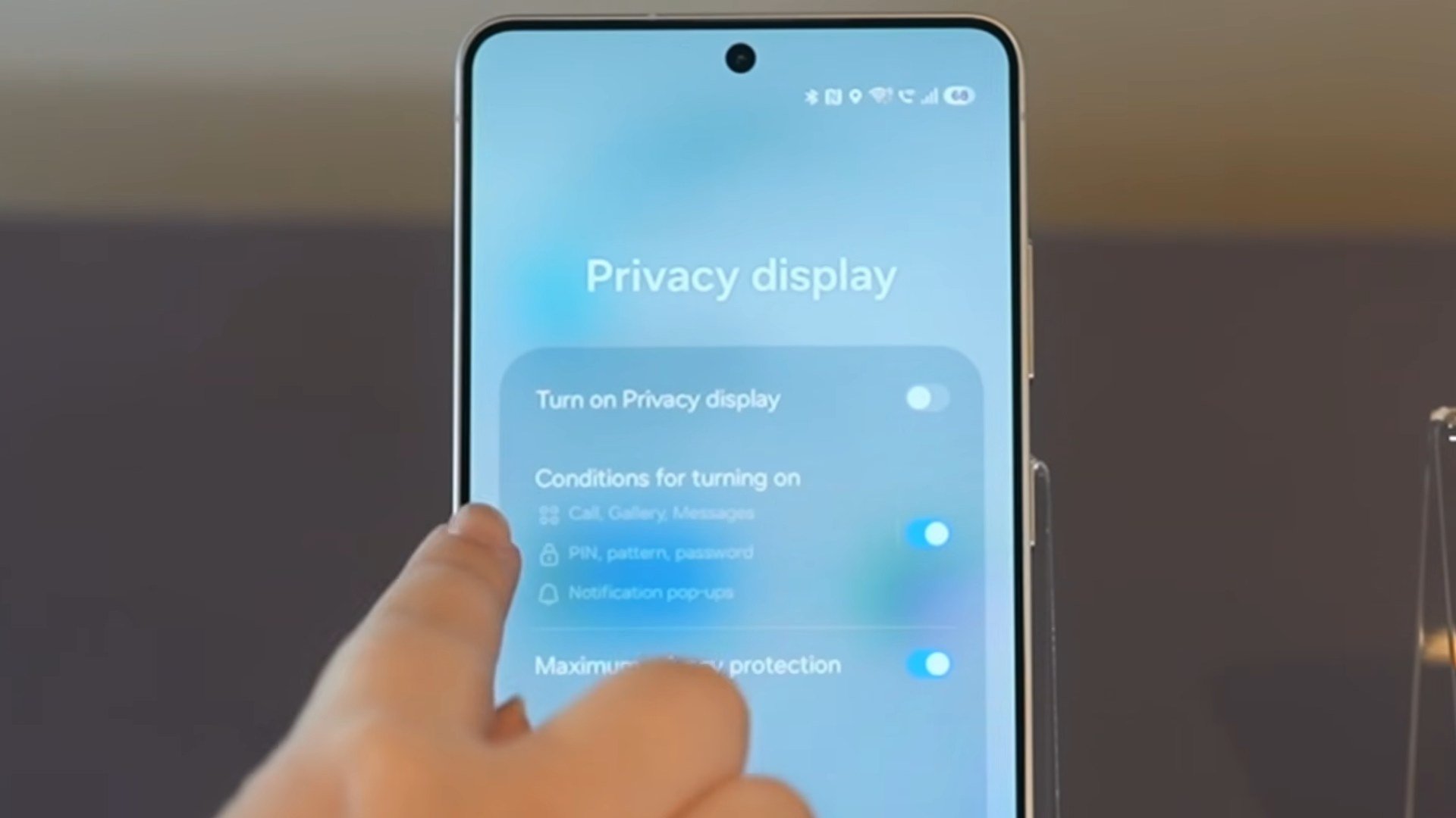 Now Nudge se activează din Setări: deget care atinge un meniu pe ecranul unui Samsung Galaxy S26