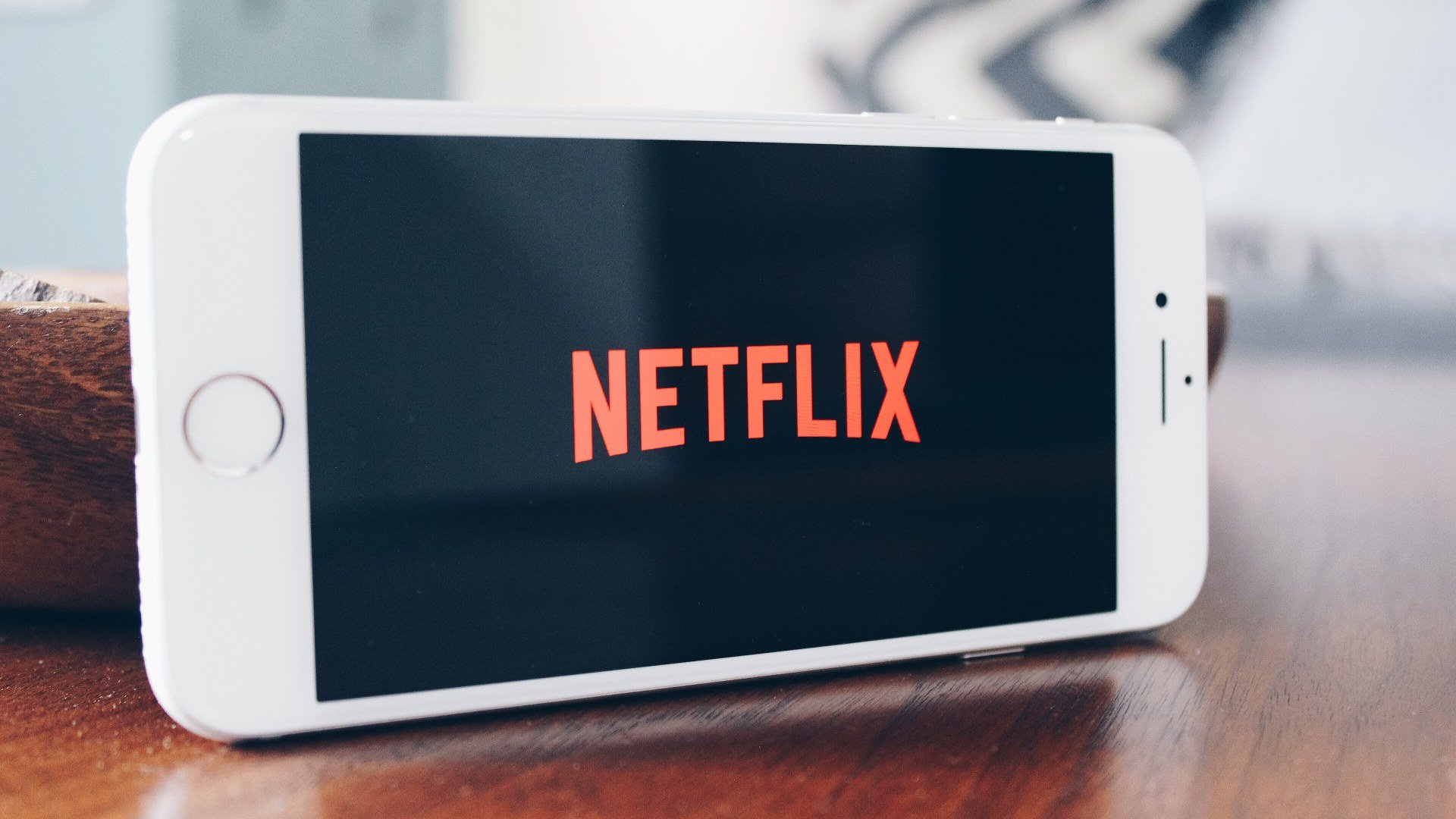 iPhone cu logoul Netflix pe ecran, de pe care poți deschide coduri Netflix în browser
