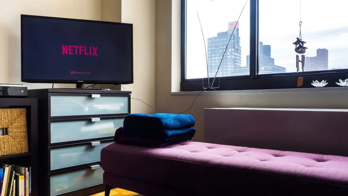 Netflix în noiembrie Televizor cu ecranul de pornire Netflix, așezat pe o comodă într-o sufragerie luminoasă