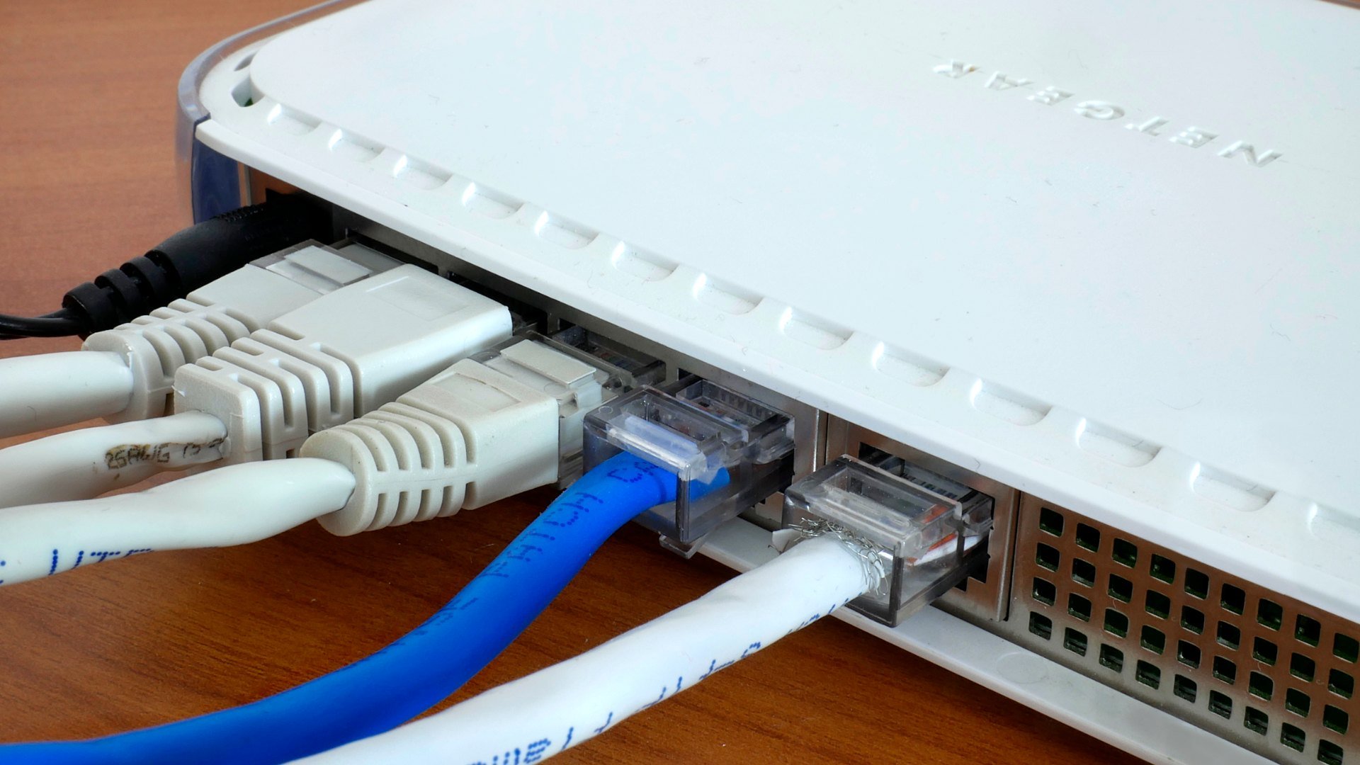 Cabluri de rețea conectate în porturile Ethernet ale unui router de acasă