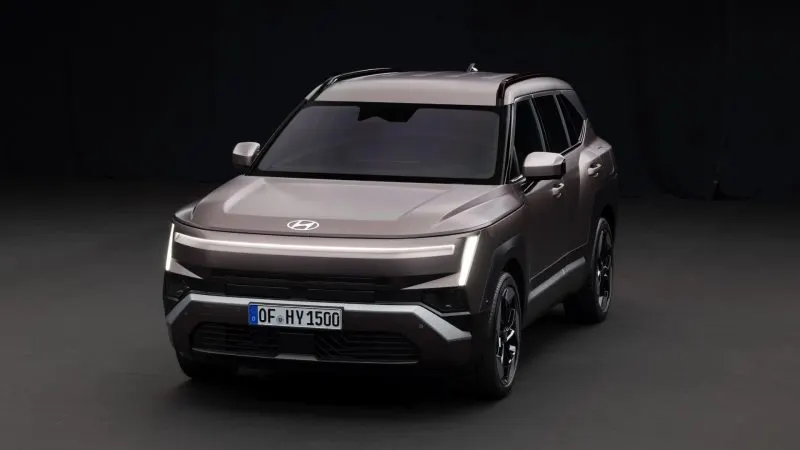 Noul Hyundai Tucson de generația a cincea, gri, văzut din față și lateral, cu semnătura luminoasă H-Edge aprinsă