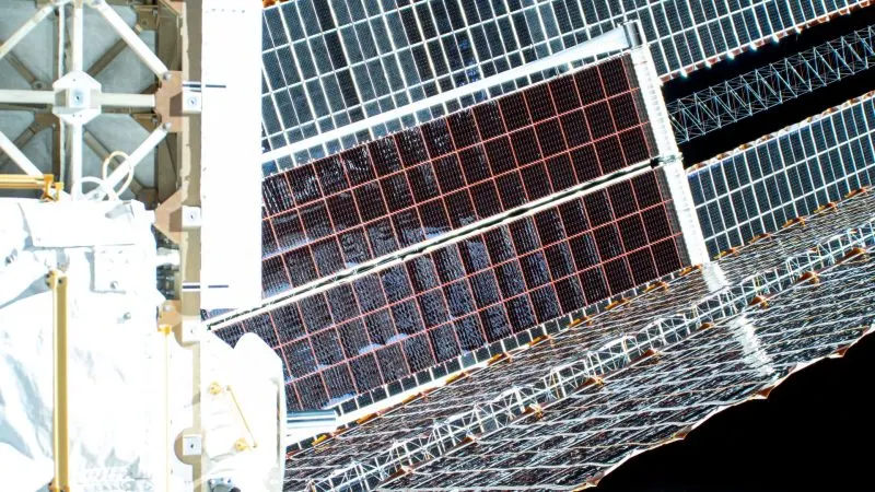 Panou solar iROSA desfășurat pe Stația Spațială Internațională, în fața unei aripi solare originale