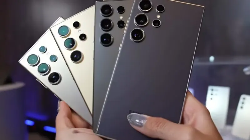 Mai multe telefoane Samsung Galaxy S24 Ultra ținute în evantai, cu camerele din spate vizibile