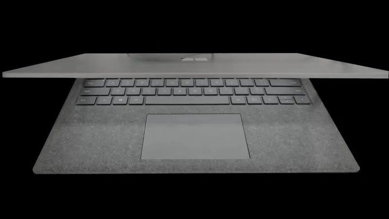 Laptop Microsoft Surface argintiu deschis, cu tastatura și touchpadul mare vizibile