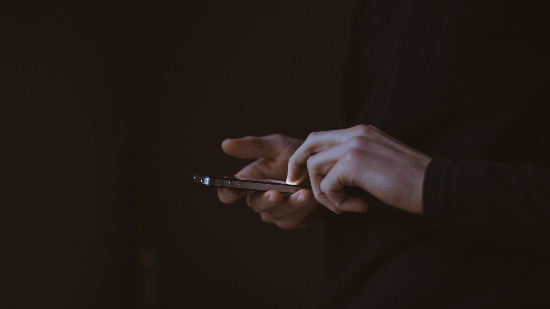 Bărbat care folosește un smartphone, după ce livrările de smartphone-uri au scăzut cu 22%