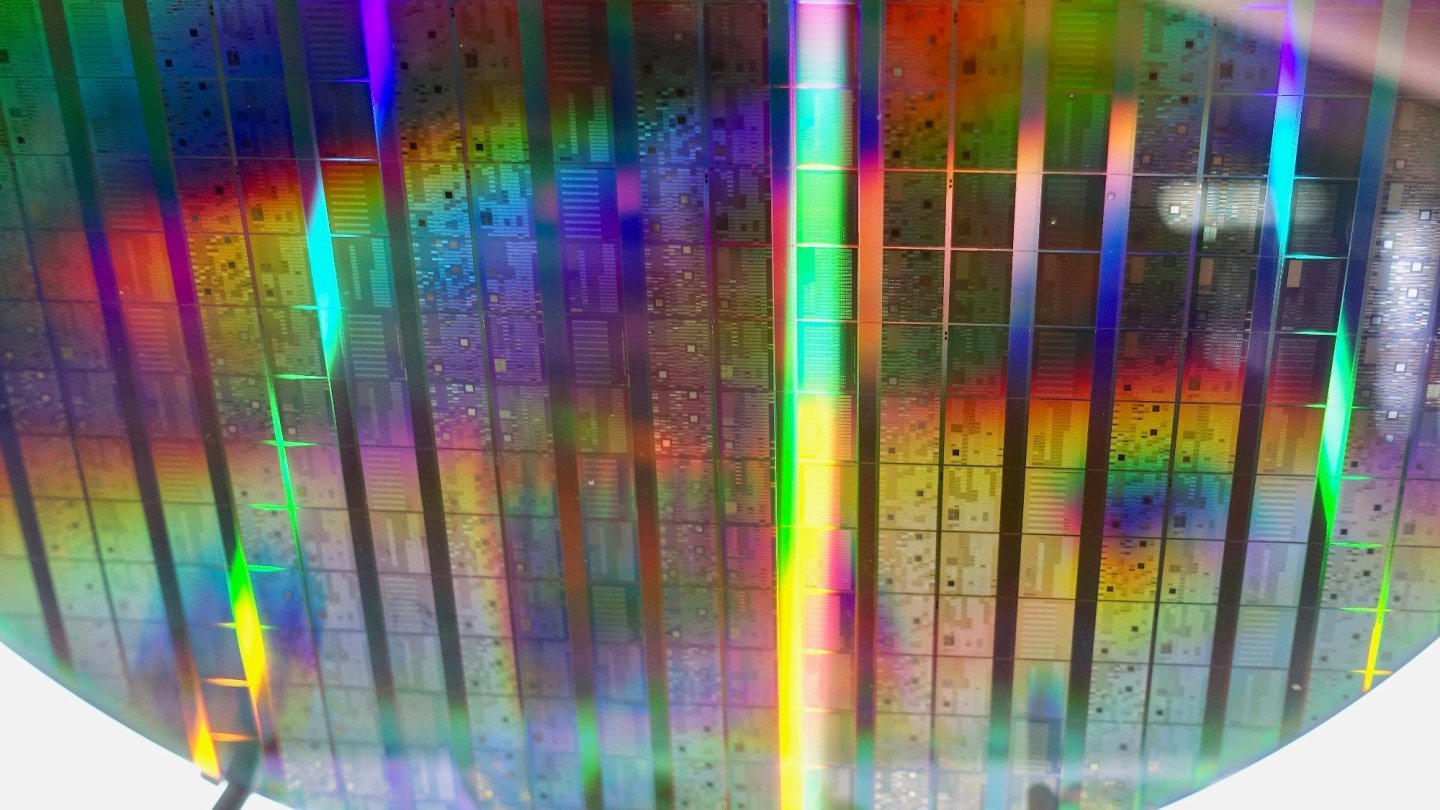 O placă de siliciu cu zeci de cipuri cuantice Intel, care reflectă lumina în culorile curcubeului