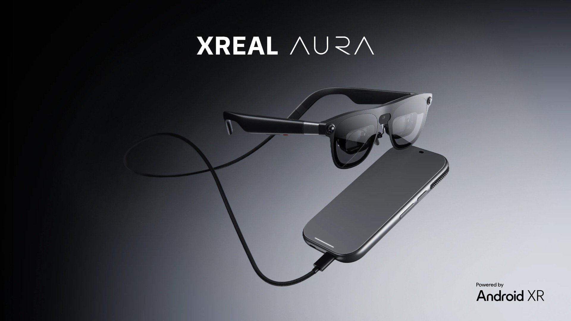 XREAL Aura Imaginea oficială de lansare XREAL Aura, cu ochelarii și modulul de calcul pe fundal gri